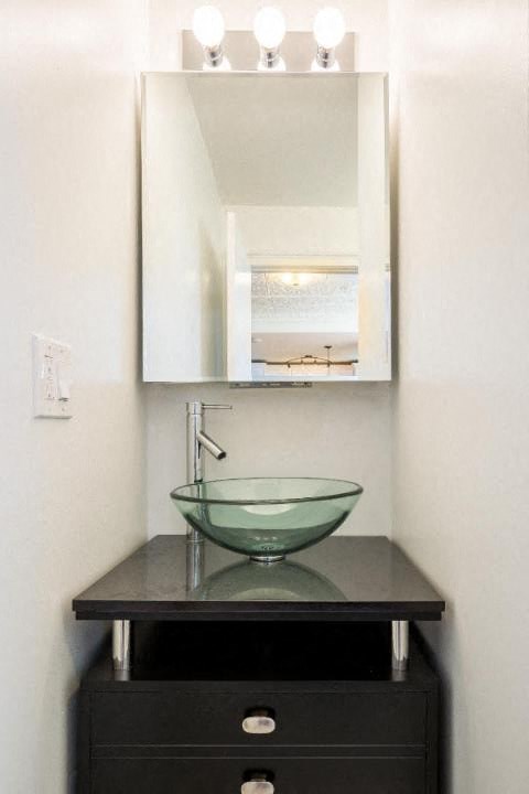 a bathroom with a bowl sink and a mirror