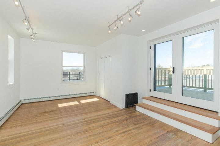 an empty living room with wood floors and a balcony