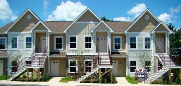 a row of white houses with stairs and a blue sky