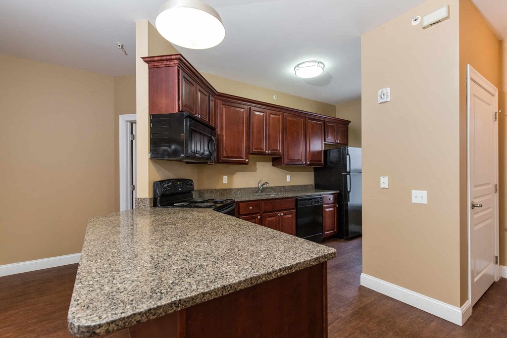 a kitchen with granite counter top and black appliances