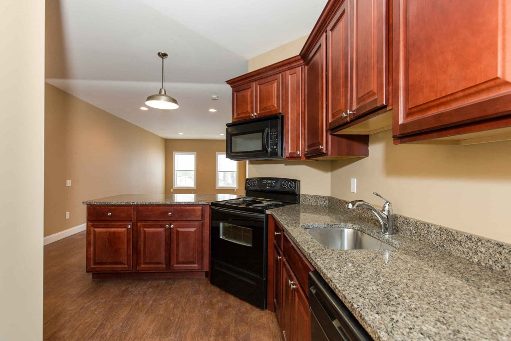a kitchen with granite counter tops and black appliances