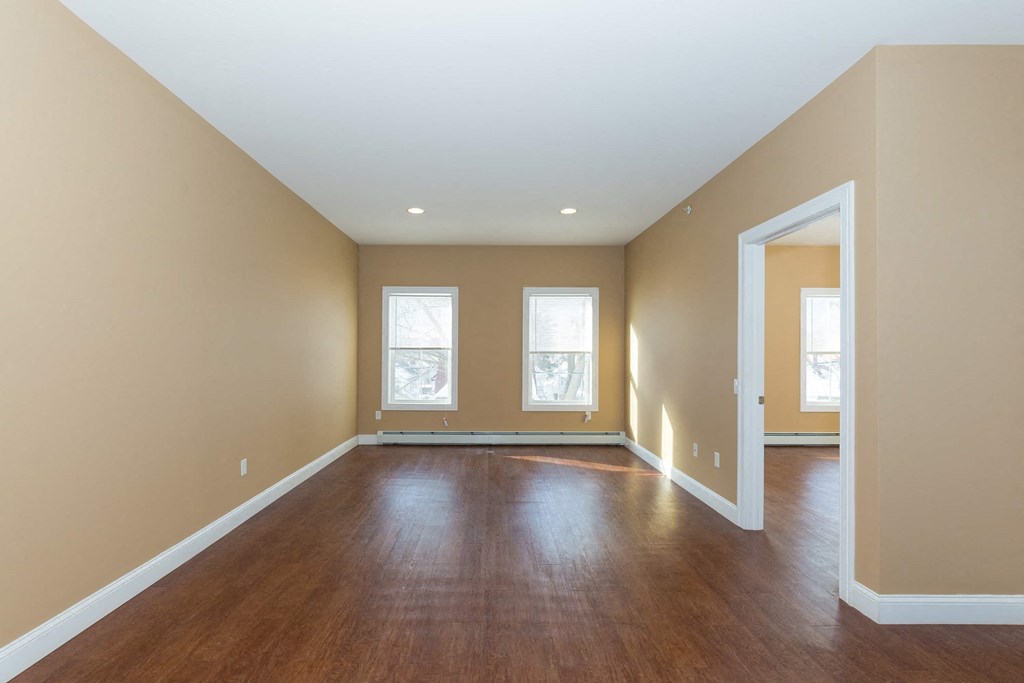 an empty living room with hardwood floors and a window