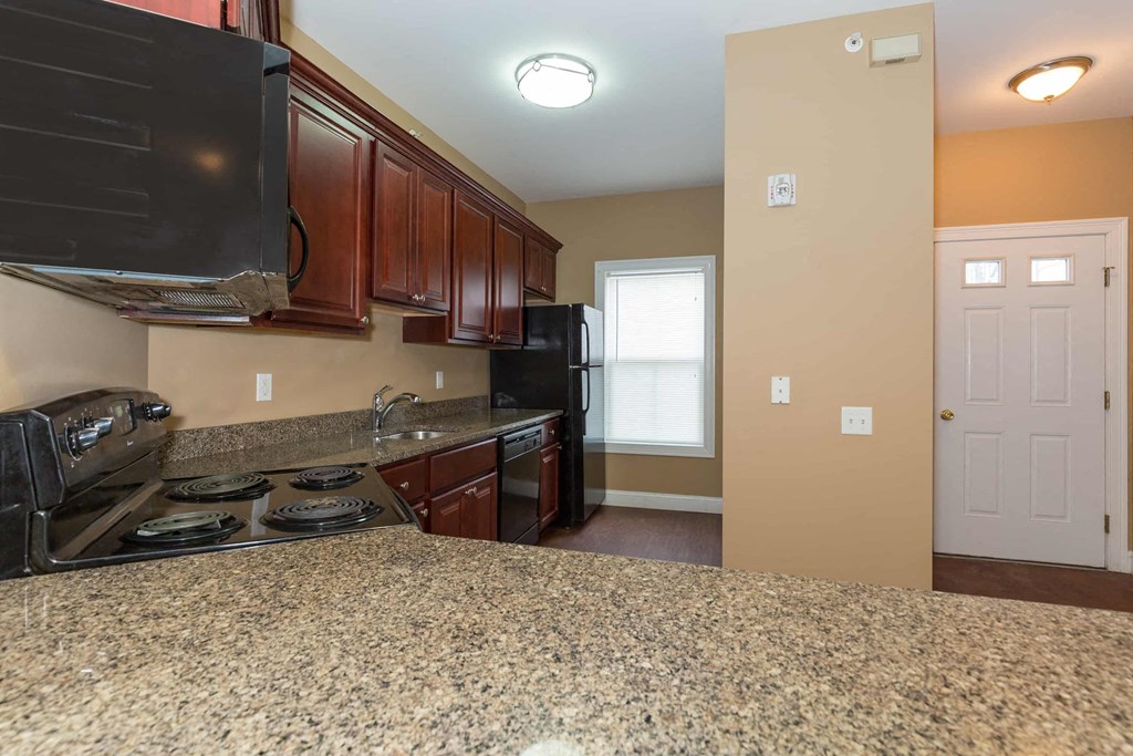 a kitchen with granite counter tops and a black stove