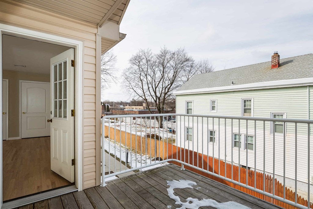 a balcony with a white fence and a door to a house