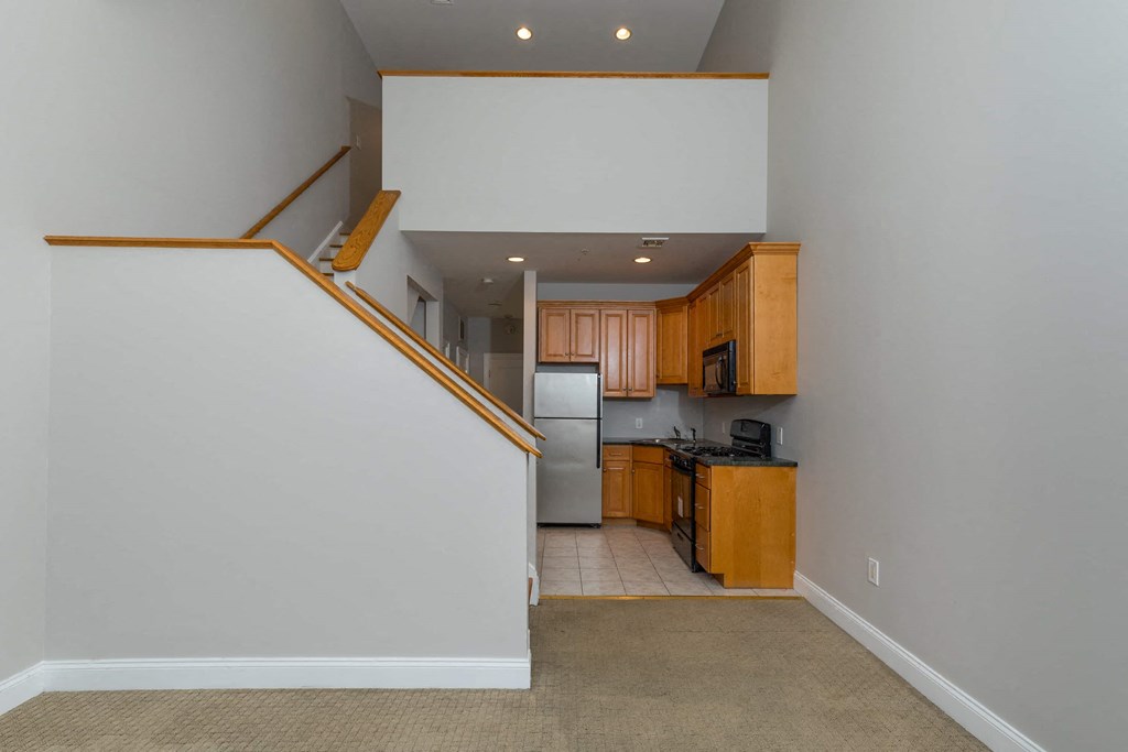 a view of a kitchen from the bottom of a staircase