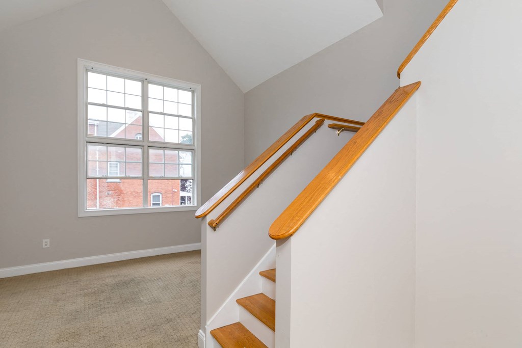 a staircase in a home with a window and a carpeted floor