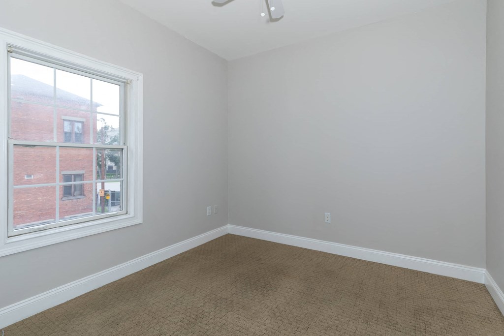 an empty room with a window and carpet