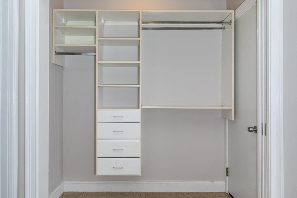 a large white closet with shelves and drawers