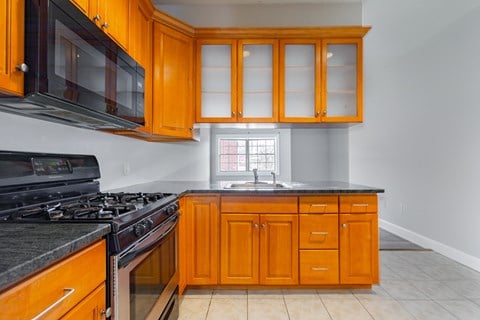 a kitchen with orange cabinets and a stove and a microwave