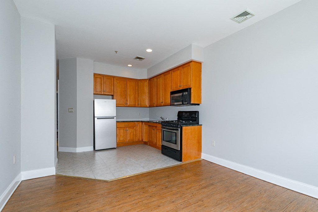 a kitchen with wooden cabinets and a stove and refrigerator