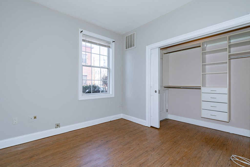 an empty bedroom with a closet and a window