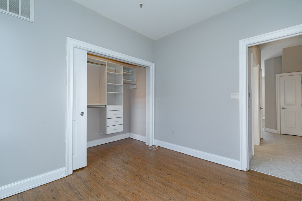 a bedroom with a closet and a hard wood floor