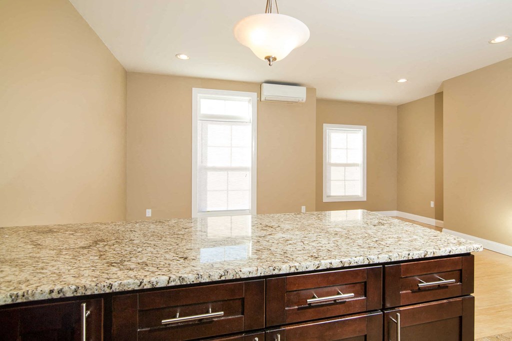 a kitchen with a marble counter top and wooden cabinets