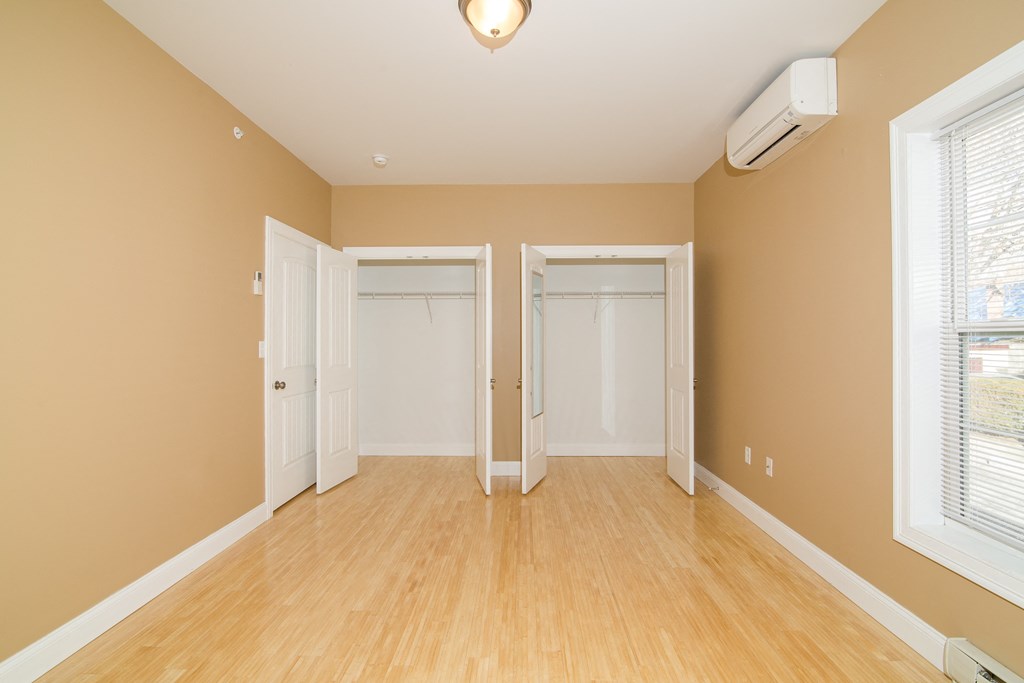 an empty living room with wood floors and a closet