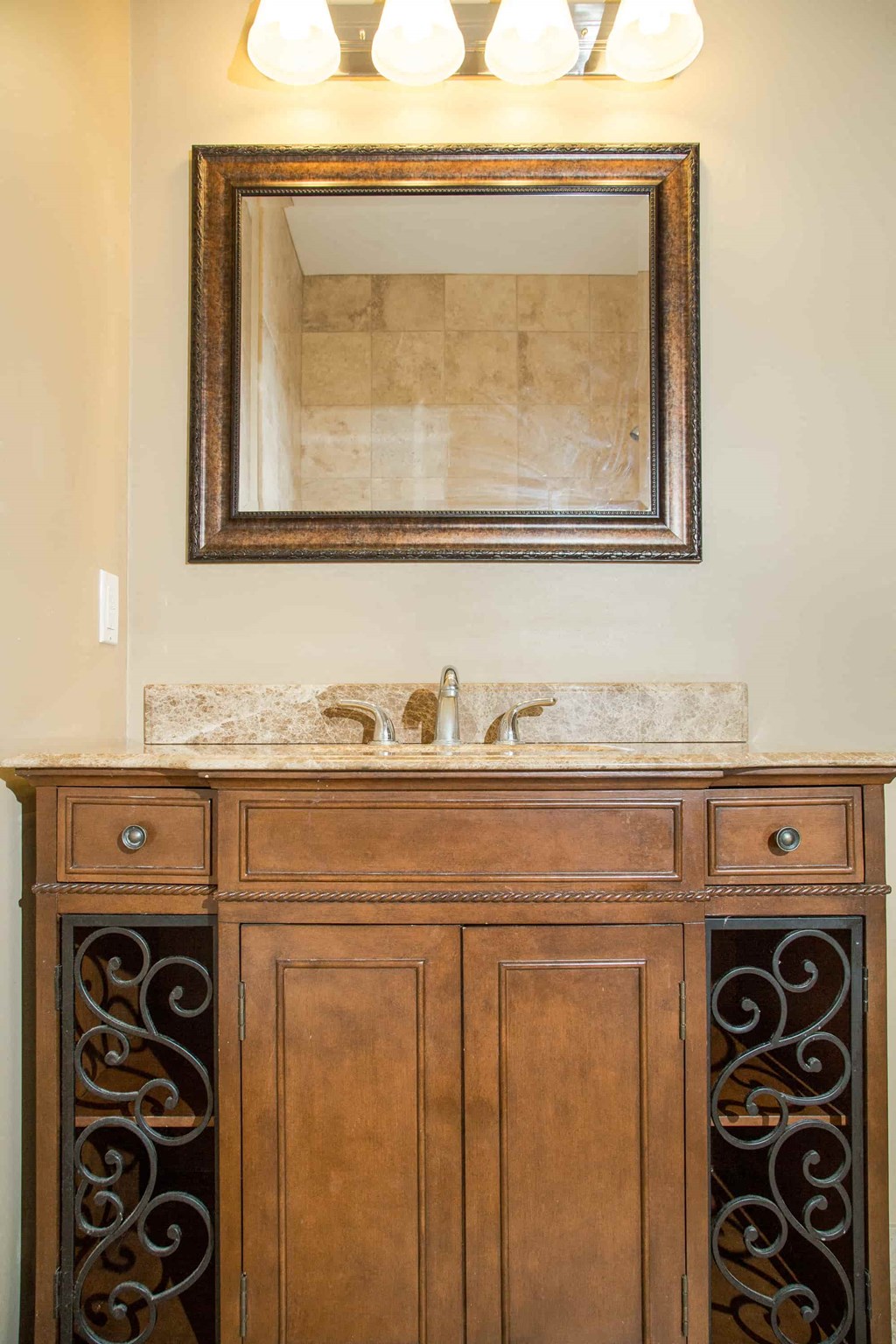 a bathroom sink with a wooden cabinet and a mirror