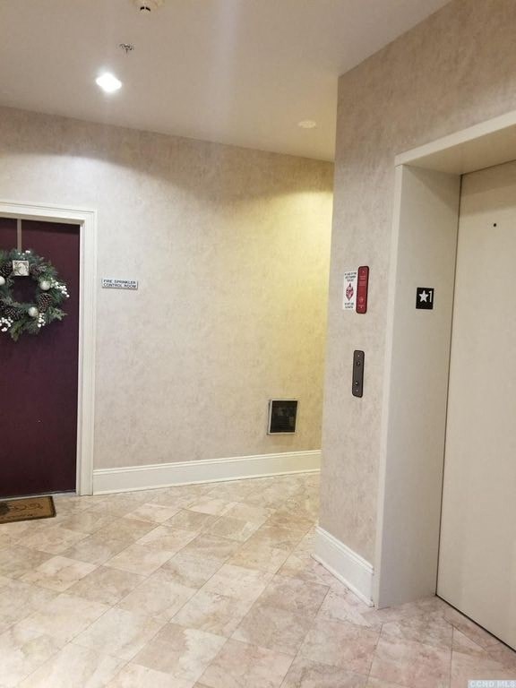 a hallway with a door and a wreath on the wall
