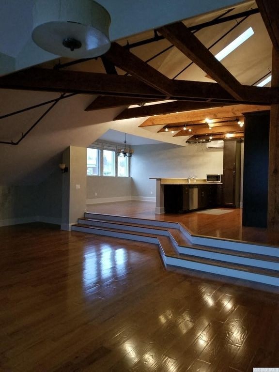 a large room with a wooden floor and stairs