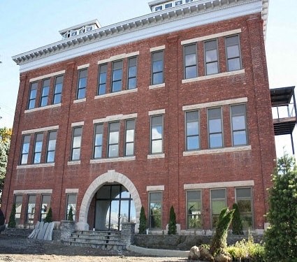 a large brick building with a staircase in front of it