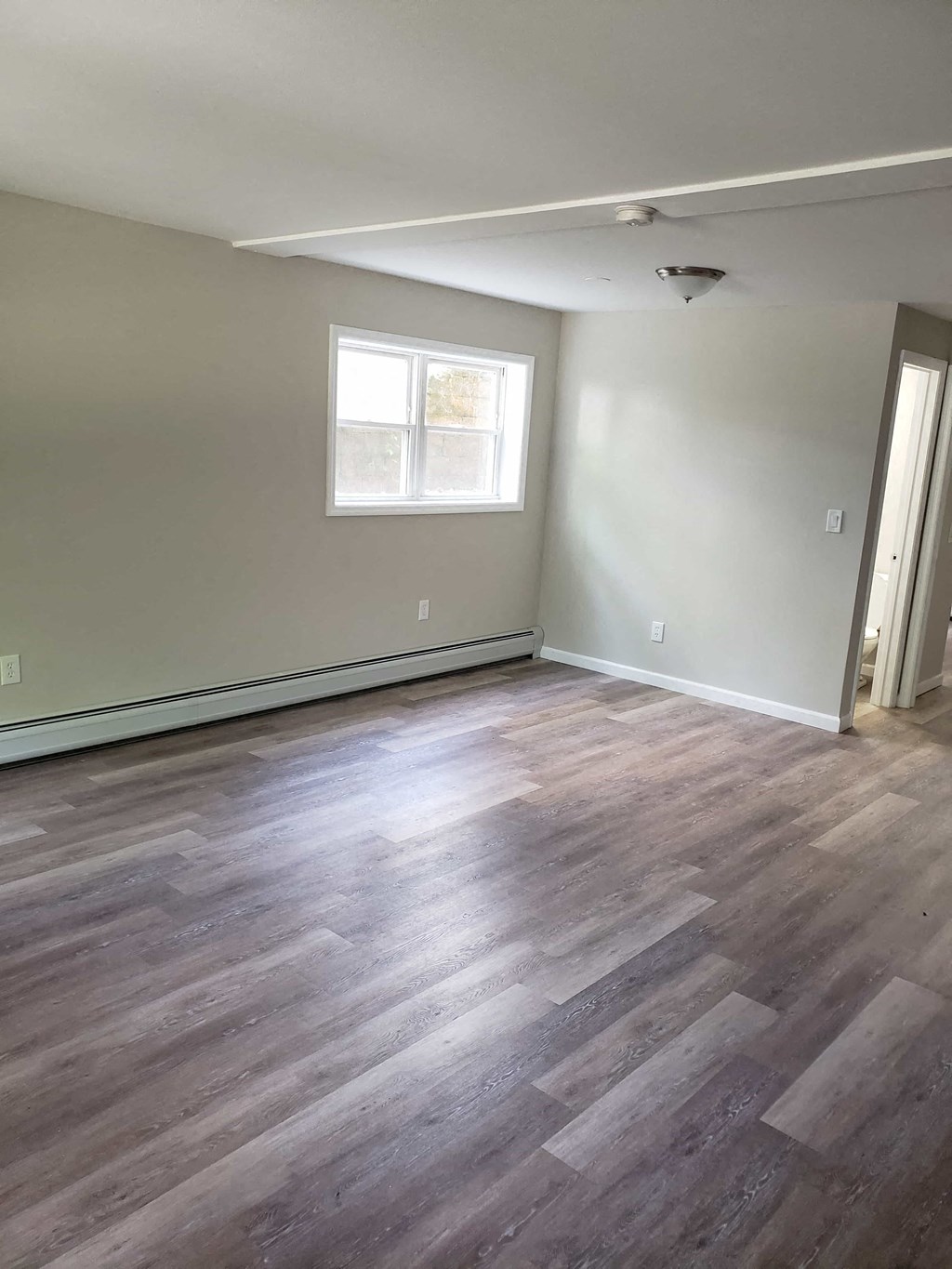 a living room with wood floors and a window
