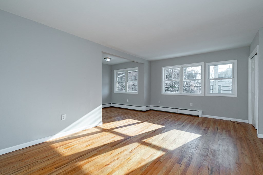 an empty living room with wood floors and grey walls