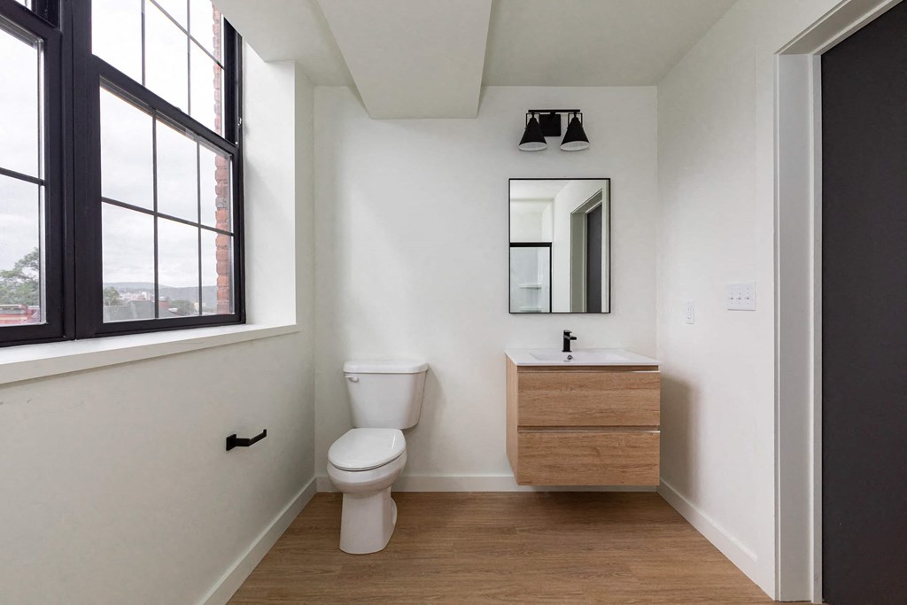 a bathroom with a toilet and a sink and a window