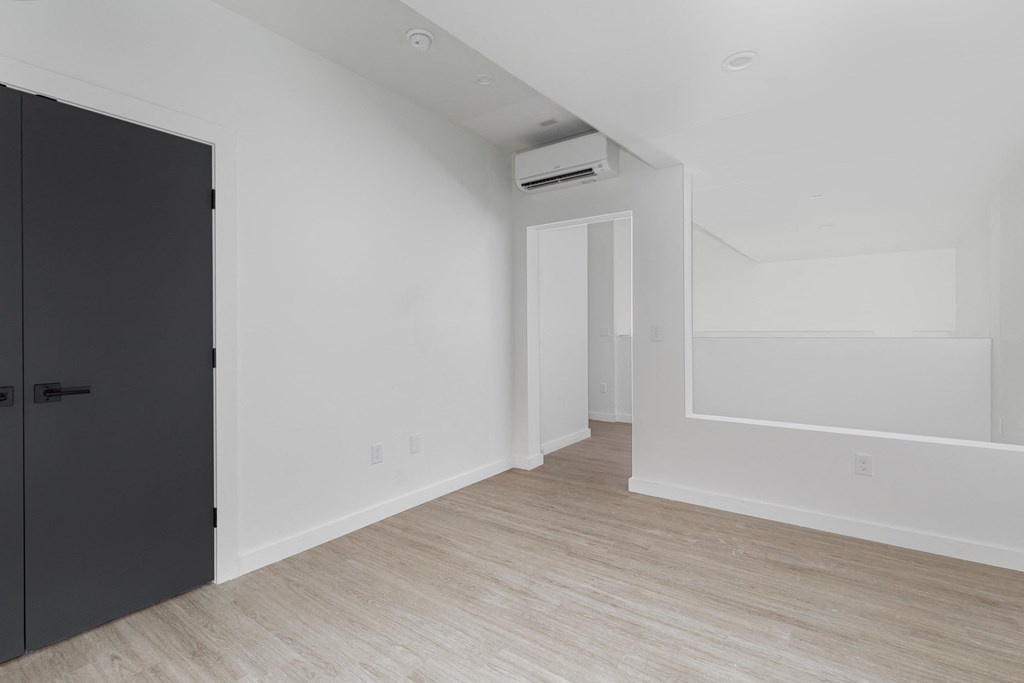 an empty room with white walls and a black door