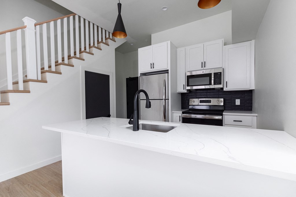 a kitchen with white cabinets and a white counter top