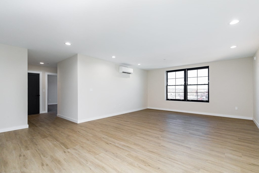 an empty living room with white walls and a window