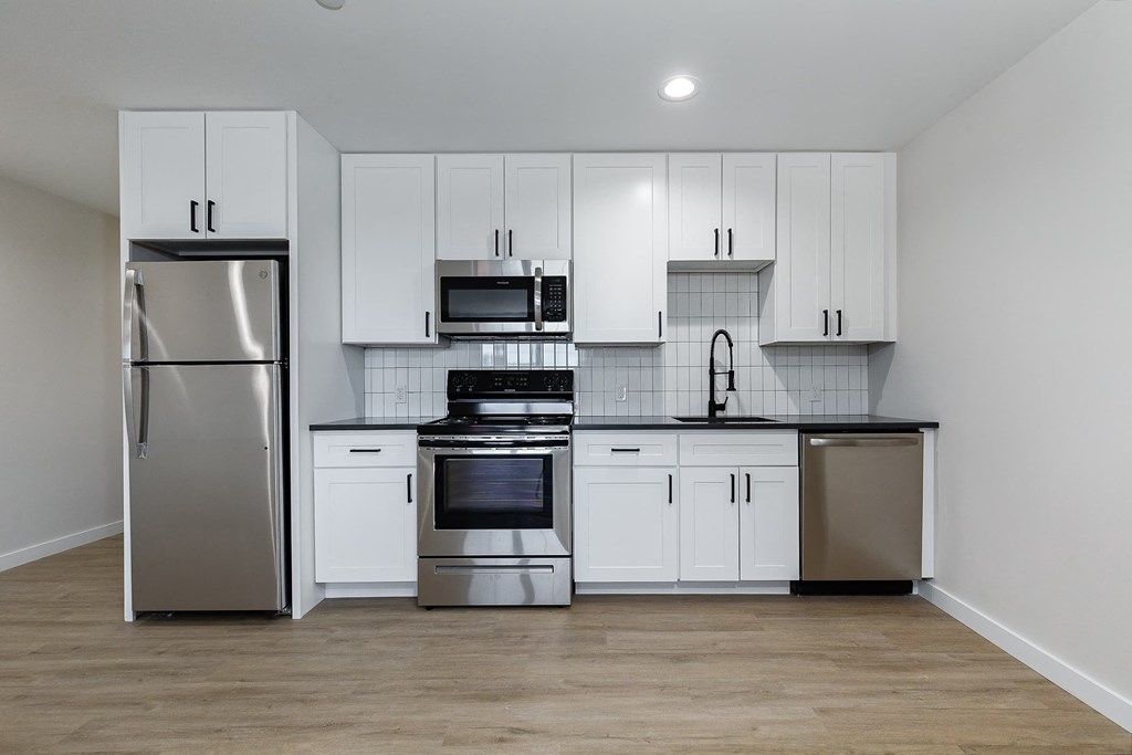 a kitchen with white cabinets and stainless steel appliances