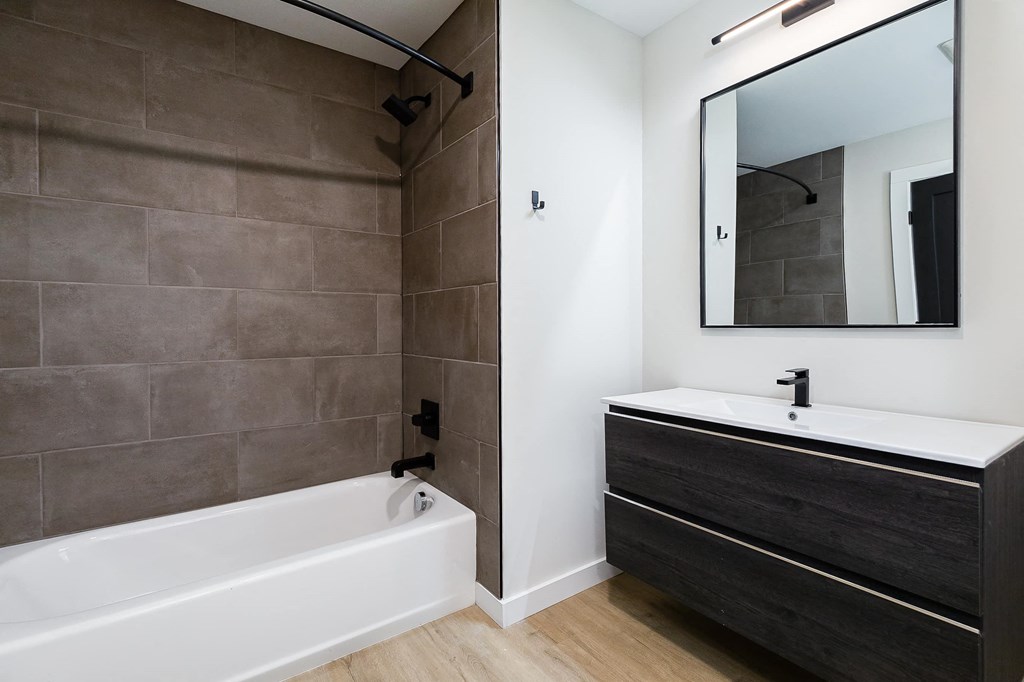 a bathroom with a tub and a sink and a mirror