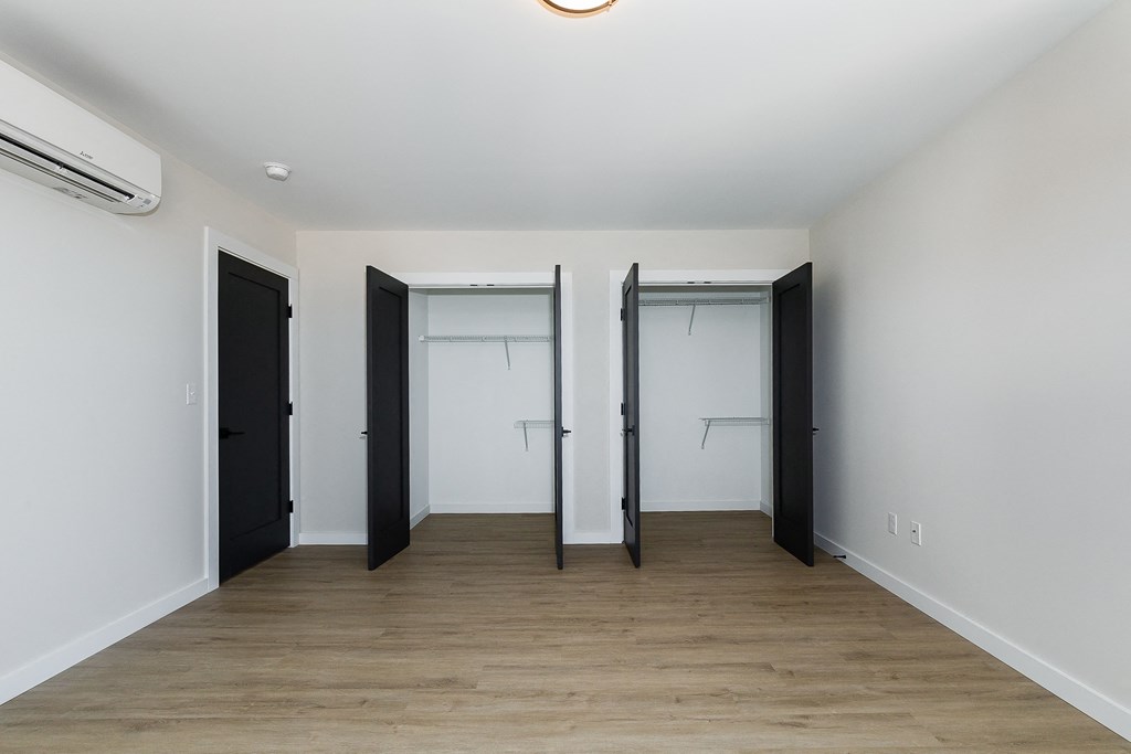 an empty room with white walls and black doors