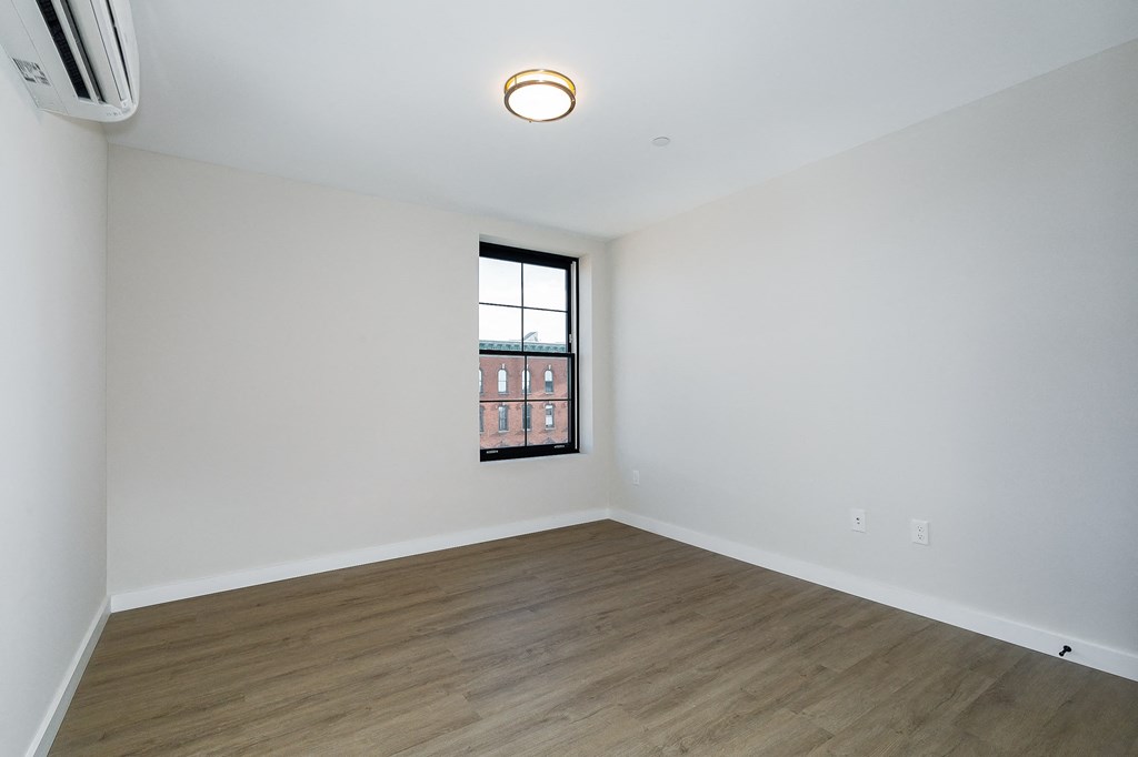 an empty living room with white walls and a window