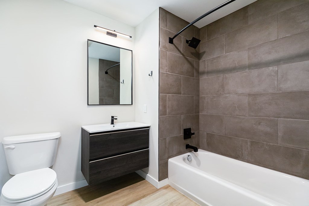 a bathroom with a toilet sink and tub and a mirror