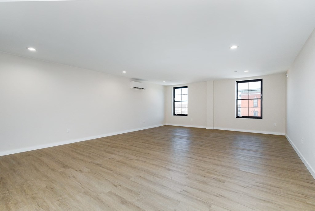 an empty living room with white walls and wood floors