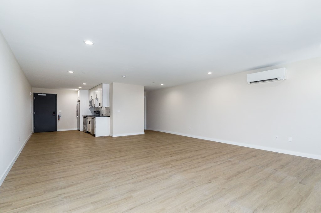 an empty living room with white walls and wood floors