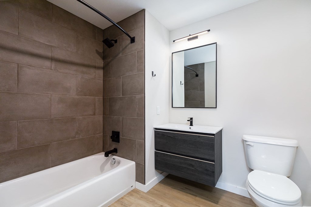 a bathroom with a toilet sink and tub and a mirror