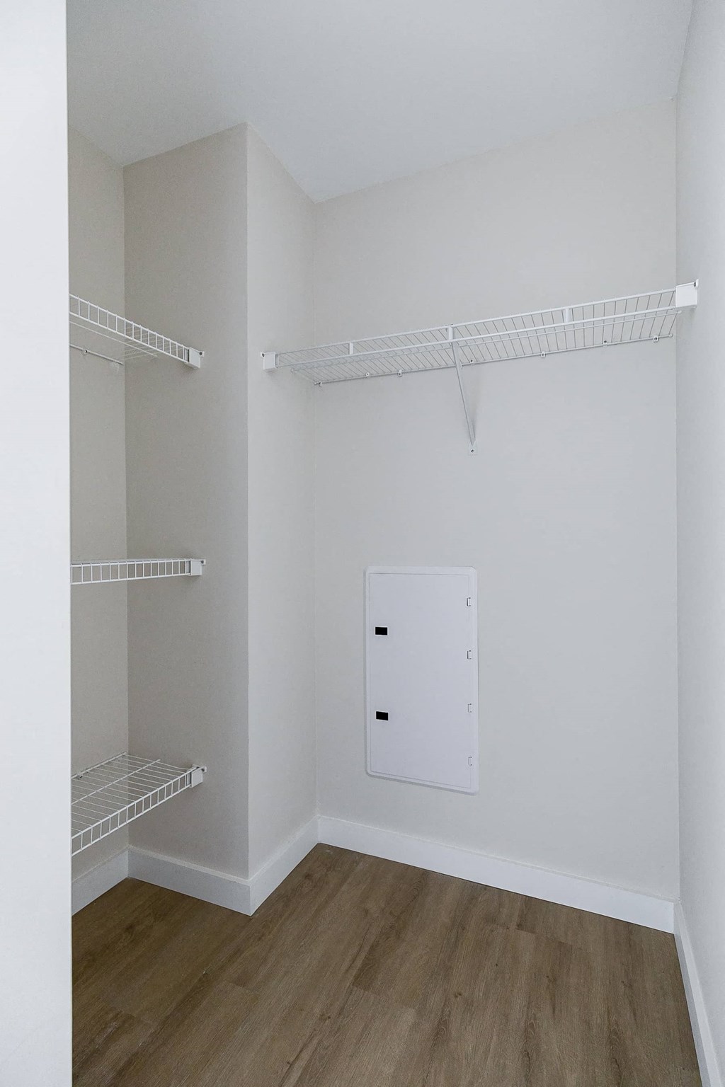 a room with a white wall and a closet with shelves
