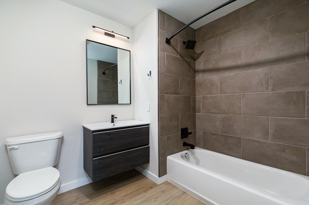 a bathroom with a toilet sink and tub and a mirror