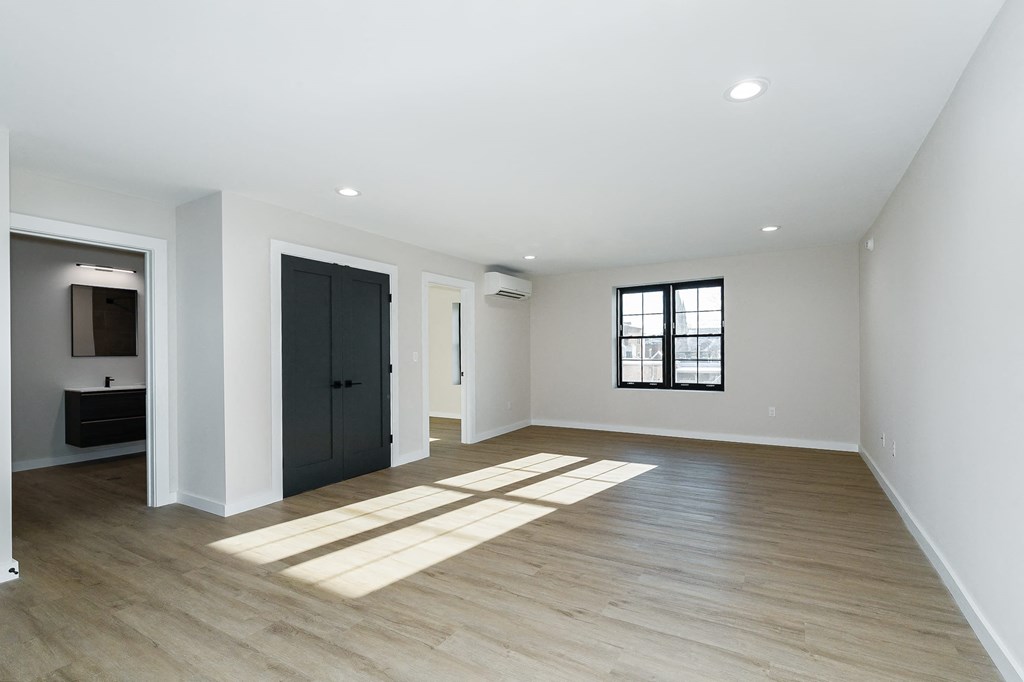 a living room with white walls and a black door