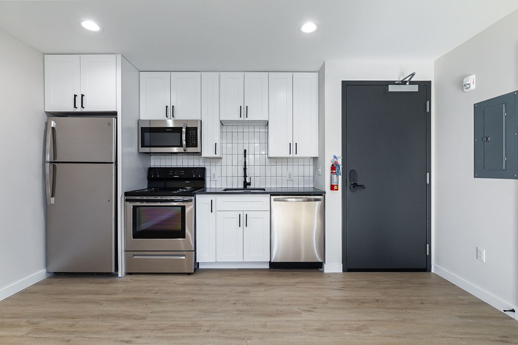 a kitchen with stainless steel appliances and white cabinets