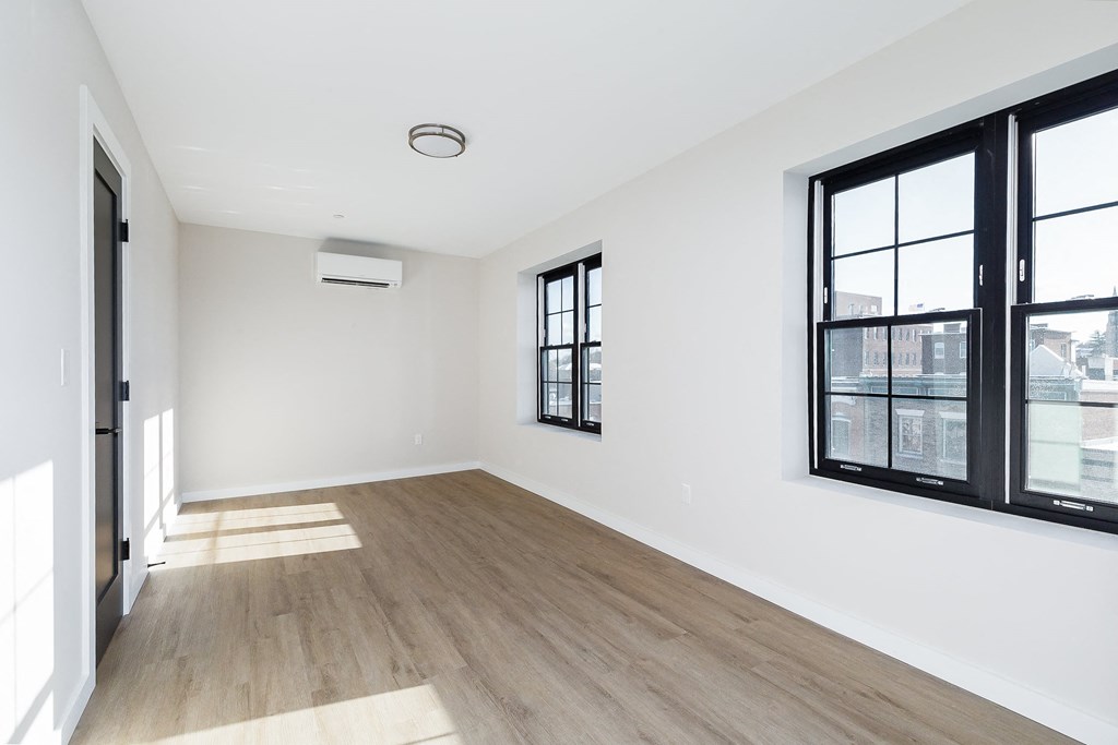 a living room with white walls and large windows