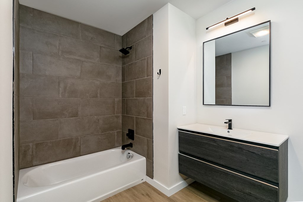 a bathroom with a sink and a tub and a mirror