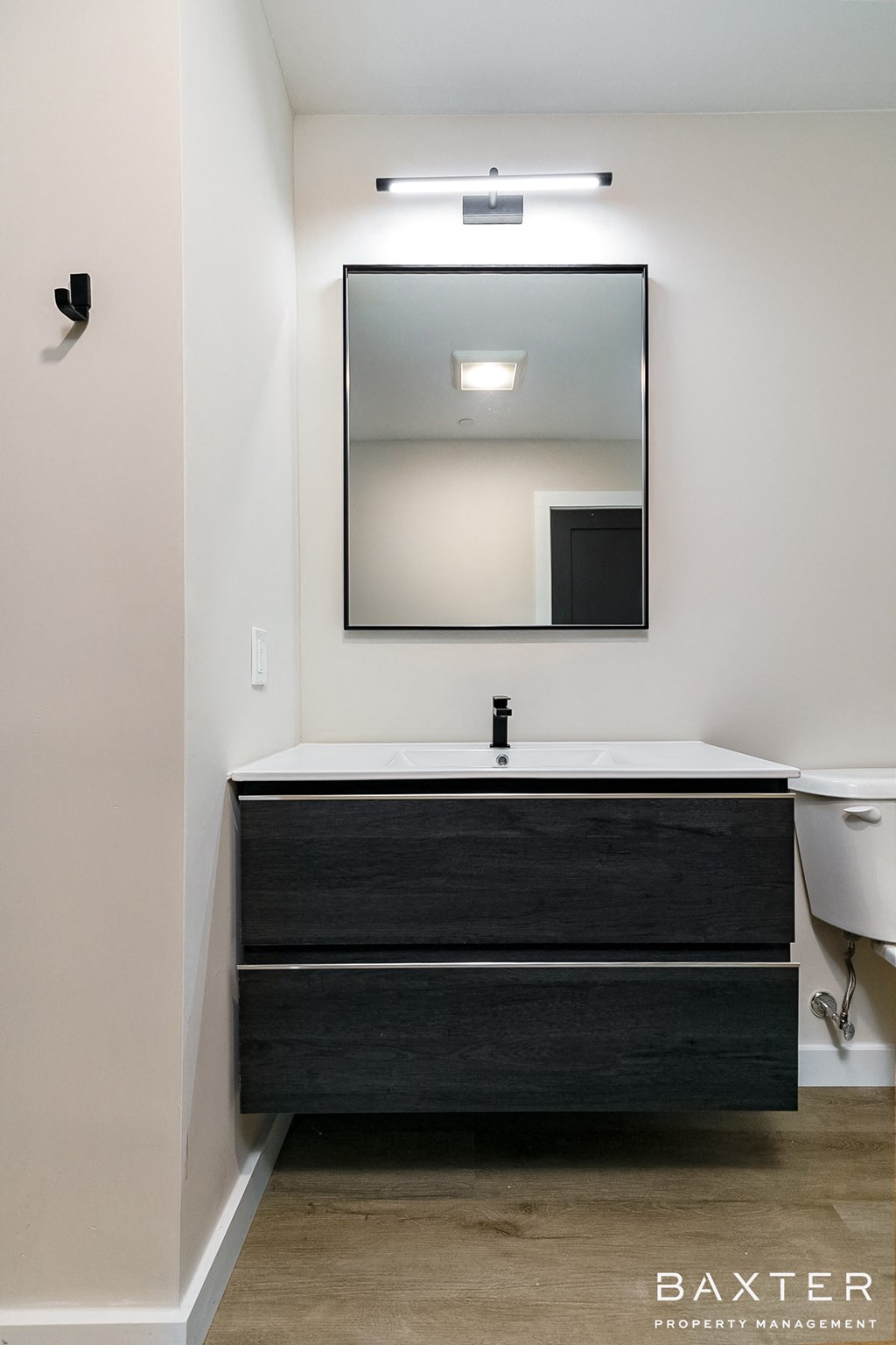 a vanity with a mirror and a toilet in a bathroom