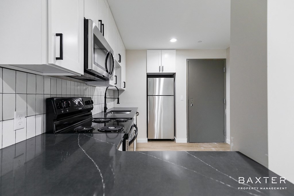 a black and white kitchen with a stainless steel refrigerator and stove