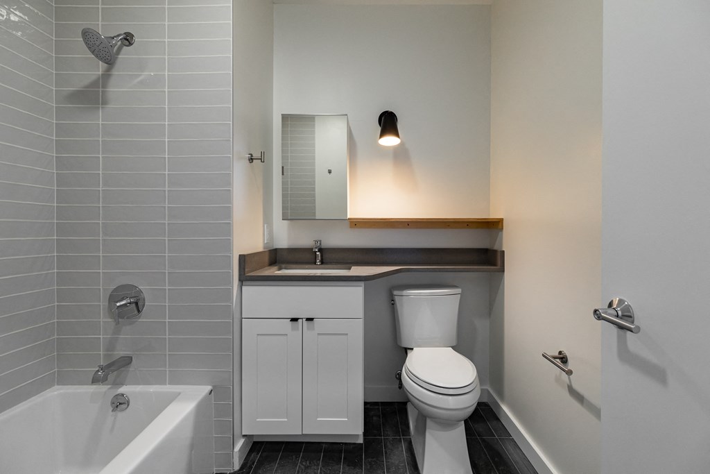 a bathroom with a toilet sink and tub and a mirror
