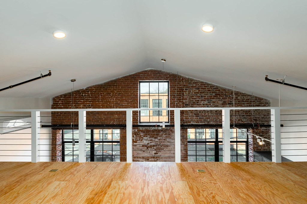 a large room with a brick wall and a wooden table