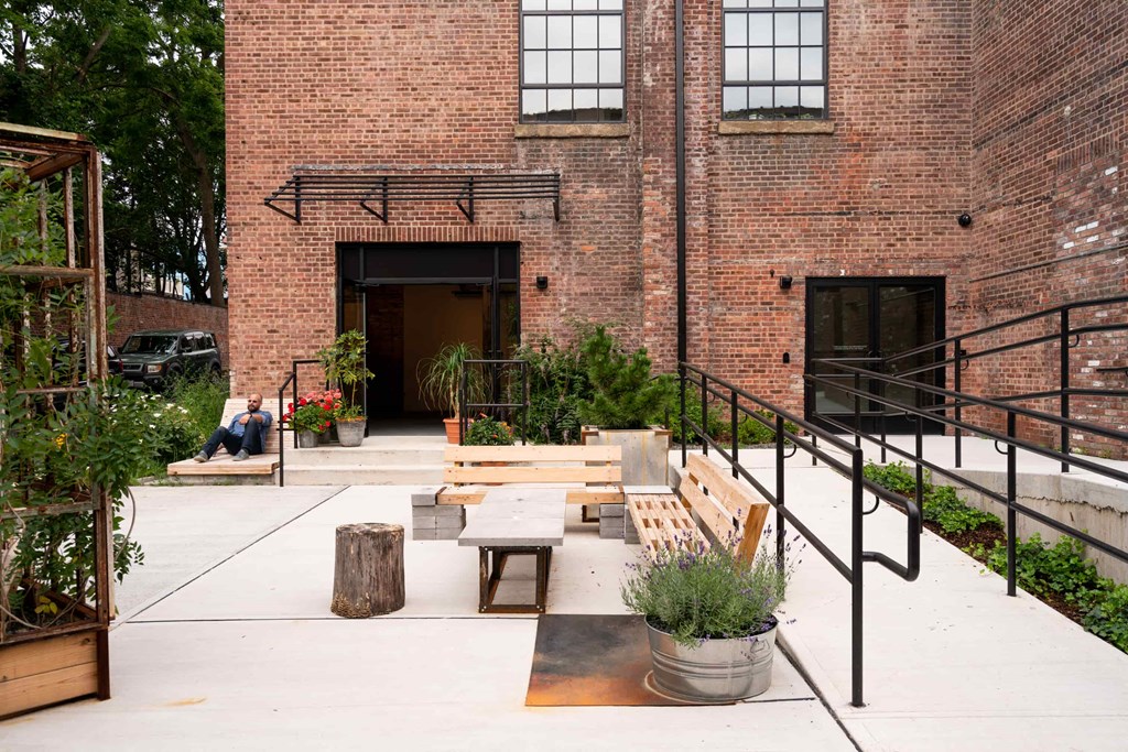 the courtyard of the building is filled with benches and plants