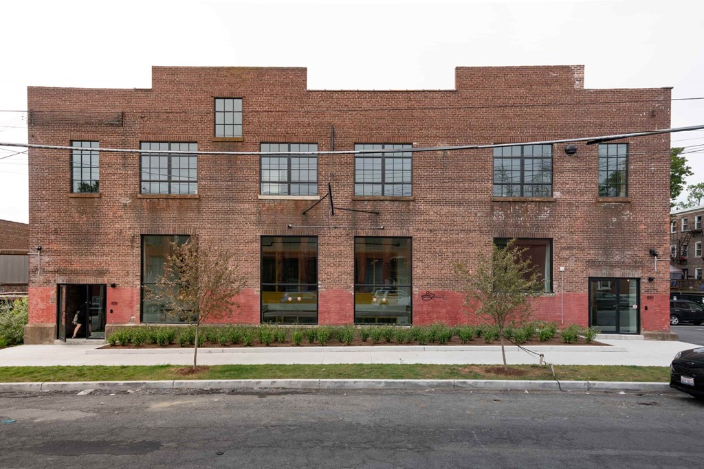 the exterior of a brick building with windows and a sidewalk
