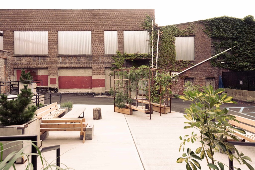 the courtyard of the building has wooden benches and plants