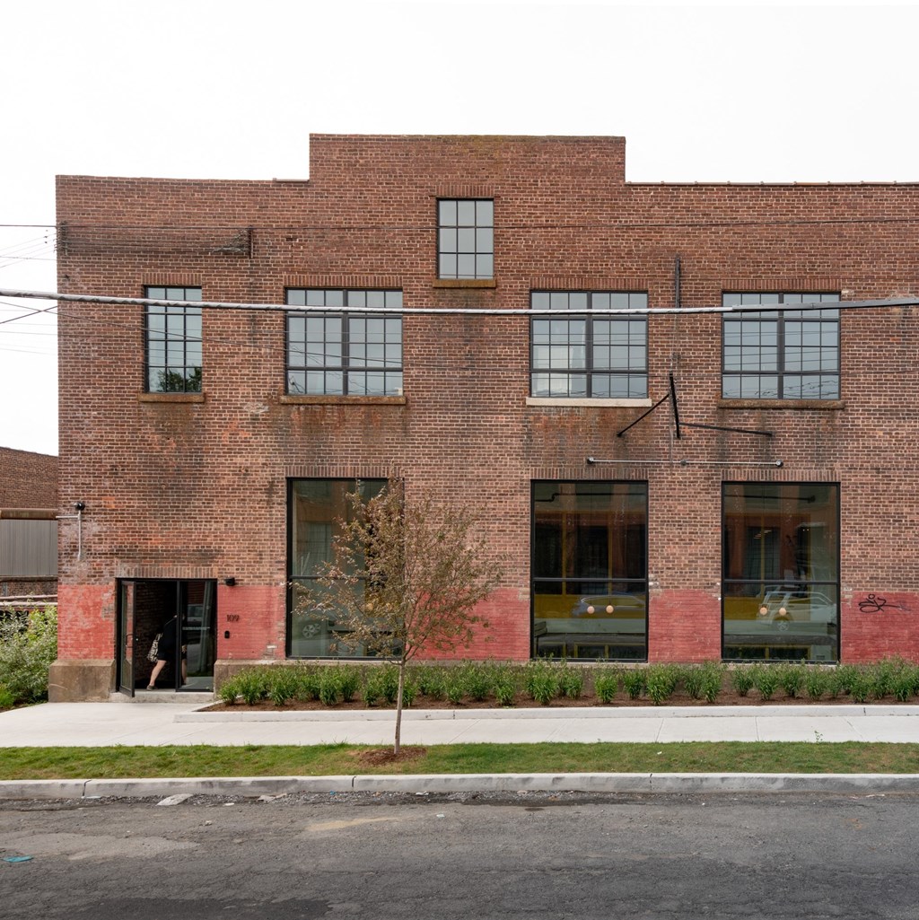 a brick building with windows and a sidewalk